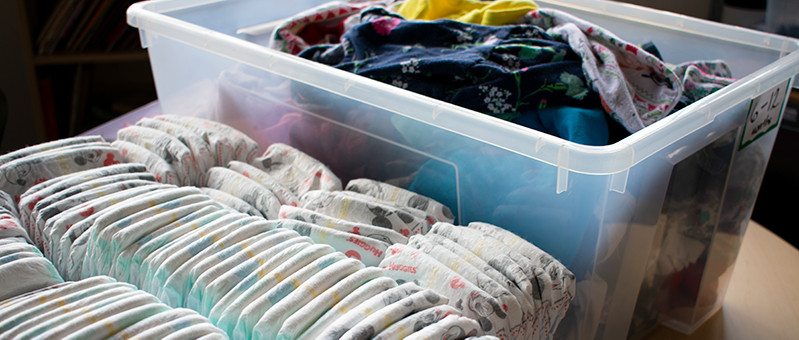 Quần áo em bé và tã được gấp gọn gàng để quyên góp